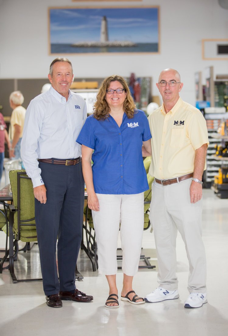 Opening A New Store That Stands Out 3 Bob Taylor, Do it Best president emeritus (left), was on hand to join owners Kathryn Tatterson and Sterling Hudgins for the grand opening of M&M Building Supply’s third store. On the back wall is a historical painting of the New Point Comfort Lighthouse, the third-oldest surviving light on the bay.