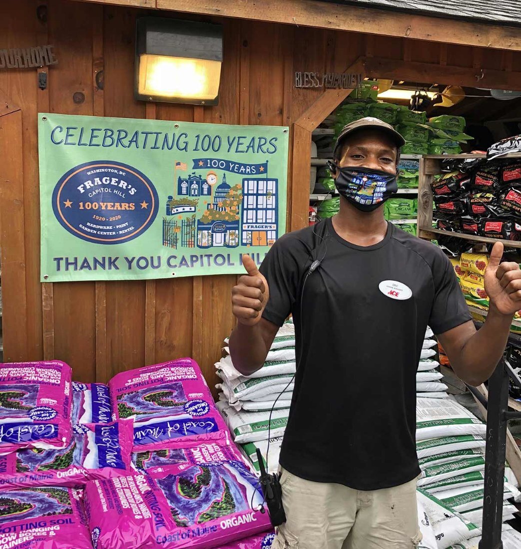 Frager’s Hardware Turns 100! 7 Eric Crowder wears a Frager’s 100th year face mask in front of the 100-year banner calling attention to Frager’s centennial celebration.