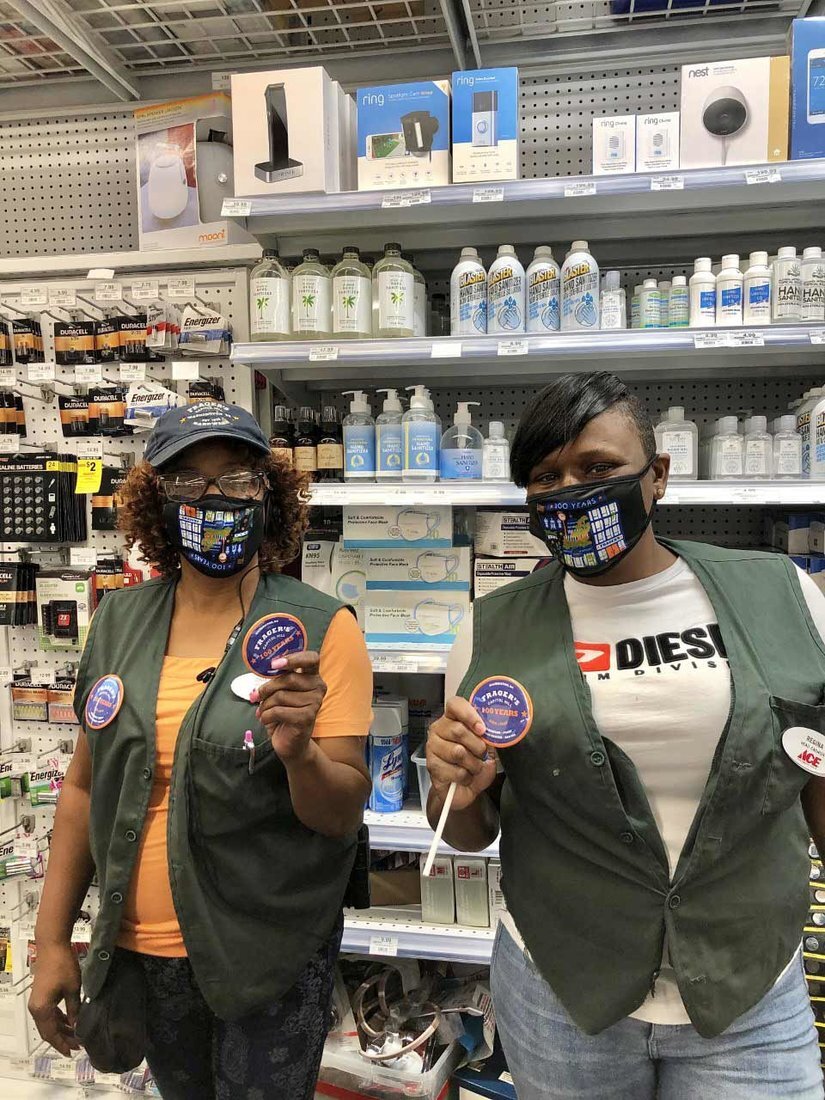 Frager’s Hardware Turns 100! 3 Zinia Brown (left) and Regina Whitaker hold the 100th anniversary Frager’s buttons worn by staff throughout the celebration month, along with the 100-year masks.